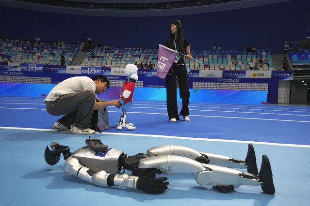 A worker prepares a robot before the opening ceremony of The World Humanoid Robot Games held in Beijing, China, Thursday, August 14, 2025. (Photo by Ng Han Guan/AP Photo)