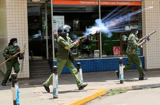 A riot police officer fires tear gas to disperse supporters of Kenya's opposition leader Raila Odinga of the Azimio La Umoja (Declaration of Unity) One Kenya Alliance, as they participate in a nationwide protest over the cost of living and President William Ruto's government in downtown Nairobi, Kenya on March 20, 2023. (Photo by Thomas Mukoya/Reuters)