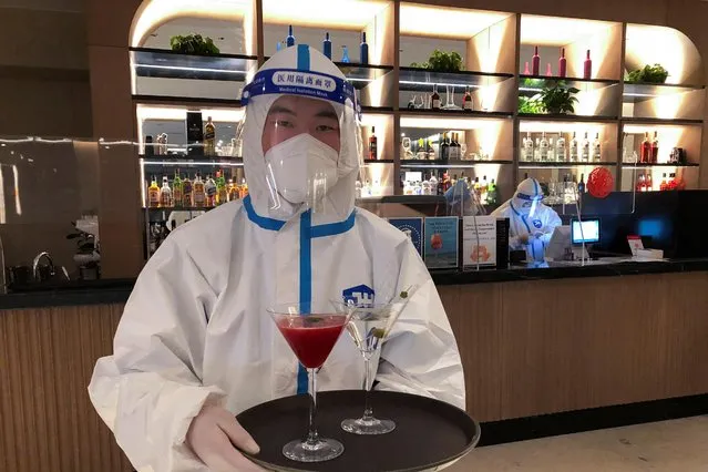 A bartender in personal protective equipment (PPE) serves cocktail in a hotel for journalists and officials of the Beijing 2022 Winter Olympics, in Zhangjiakou, China, February 2, 2022. (Photo by Ilze Filks/Reuters)