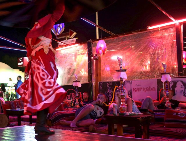 Tourists watch a traditional tannoura dance at a cafe in the Red Sea resort of Sharm el-Sheikh, Egypt November 10, 2015. (Photo by Asmaa Waguih/Reuters)