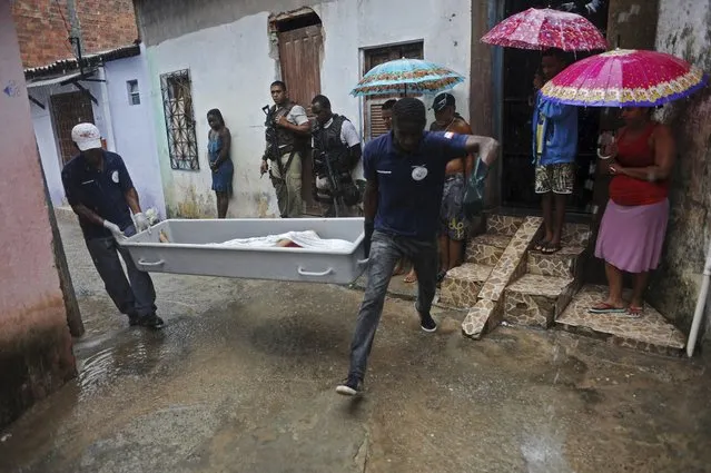 The body of a person identified by the police as a transvestite named Rodrigo, is removed by police forensic workers from the street where he was shot in the Alto do Cabrito slum of Salvador, Bahia State, March 30, 2013. (Photo by Lunae Parracho/Reuters)