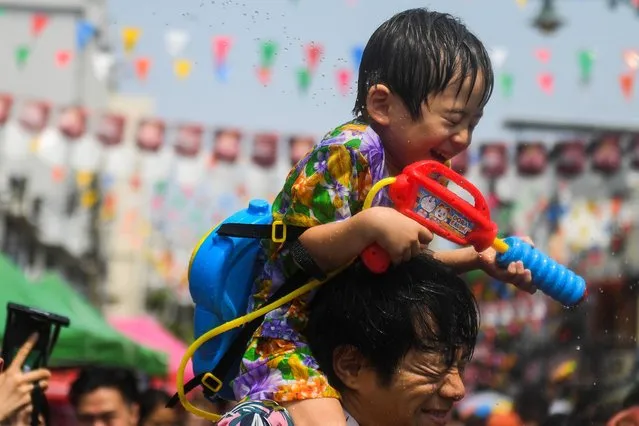 People play with water as they celebrate the Songkran holiday which marks the Thai New Year in Bangkok, Thailand on April 13, 2023. (Photo by Chalinee Thirasupa/Reuters)