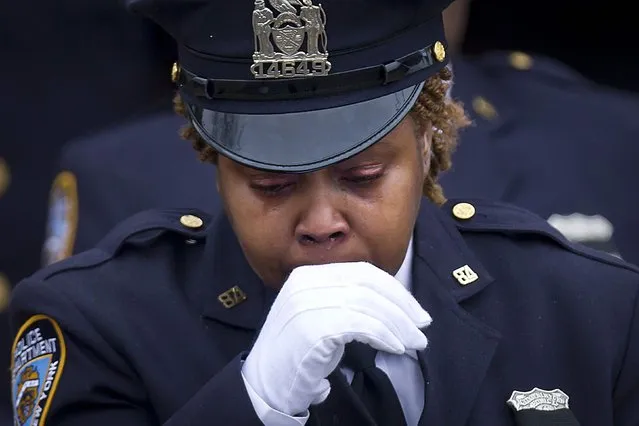 A police officer departs from the funeral for slain New York Police Department officer Wenjian Liu in the Brooklyn borough of New York January 4, 2015. (Photo by Carlo Allegri/Reuters)