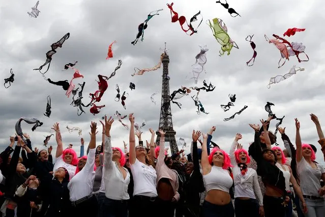 Tens of women throw their bras into the air as part of the annual Pink Bra Toss, in front of the Eiffel Tower, in Paris, Sunday, May 13, 2018. The event organised by Pink Bazaar aims to raise breast cancer awareness. (Photo by Christophe Ena/AP Photo)