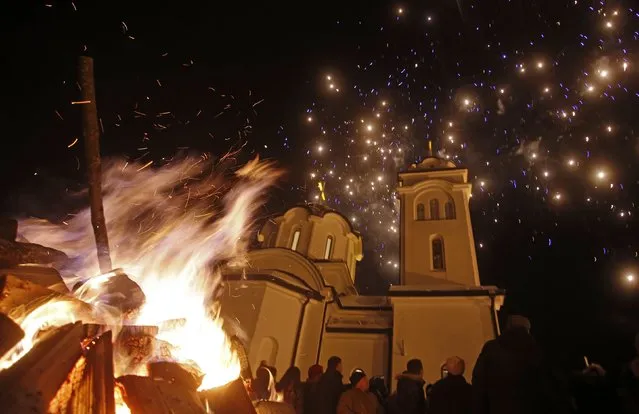 Burning Yule logs and fireworks are seen in front of Sokolica church during the eve of the Orthodox Christmas, in Ravna Romanija January 6, 2015. Most Orthodox Christians celebrate Christmas according to the Julian calendar on January 7, two weeks after most western Christian churches that abide by the Gregorian calendar. (Photo by Dado Ruvic/Reuters)
