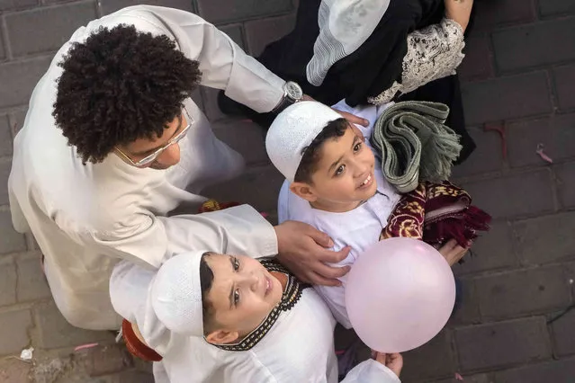 Egyptian Muslims hold a balloon distributed for free after Eid al-Fitr prayers, marking the end of the Muslim holy fasting month of Ramadan outside al-Seddik mosque in Cairo, Egypt, Friday, April 21, 2023. (Photo by Amr Nabil/AP Photo)