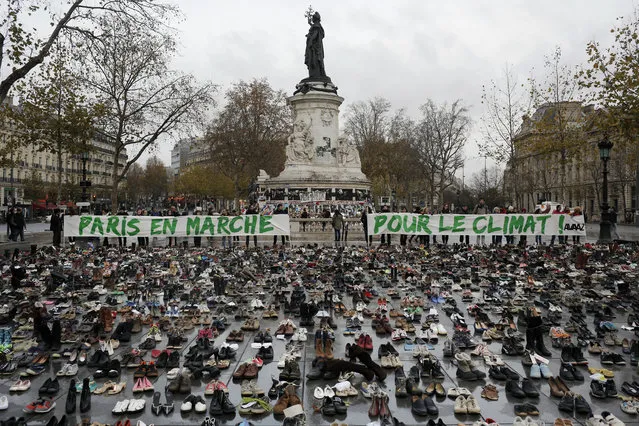 Hundreds of pairs of shoes are displayed at the place de la Republique, in Paris, as part of a symbolic and peaceful rally called by the NGO Avaaz "Paris sets off for climate", Sunday, November 29, 2015. (Photo by Laurent Cipriani/AP Photo)