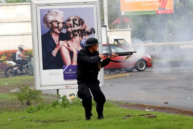 A riot police officer fires his shotgun towards university students participating in a protest against President Daniel Ortega's government in Managua, May 28, 2018. (Photo by Oswaldo Rivas/Reuters)