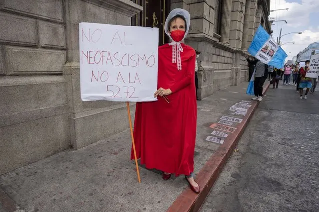 A woman dressed in a costume from the television show “The Handmaid's Tale”, stands in front of the Congress building to protest against a bill increasing sentences for women who terminate their pregnancies, prohibiting same-s*x marriage and banning discussion of sexual diversity in schools, in Guatemala City, Saturday, March 12, 2022. President Alejandro Giammattei has asked lawmakers to pull back the bill known as 5272 or face his veto. (Photo by Moises Castillo/AP Photo)