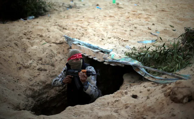 A Palestinian militant of the Democratic Front for the Liberation of Palestine (DFLP) gets out of a tunnel during a graduation ceremony in Rafah in the southern Gaza Strip November 4, 2016. (Photo by Suhaib Salem/Reuters)