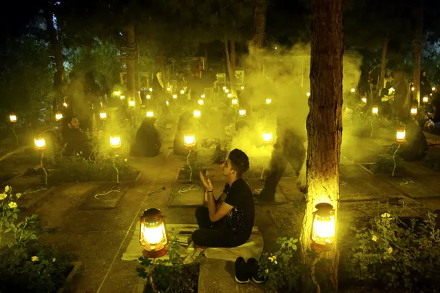 Iranian Shiite Muslims pray around the graves of Iranian Martyrs during a religious ceremony during the holy fasting month of Ramadan, at the Behesht-Zahra cemetery, in southern Tehran, Iran, 06 June 2018. Iranian Muslims spent the night in prayer until early in the morning commemorating Laylat Al Qadr (The Night of Power), which is the anniversary of the night that Muslims believe Prophet Muhammad received the first revelation of the Koran by the angel Gabriel. It is also said that is one of the odd nights of the last ten days of holy month of Ramadan and is better than 1,000 months of worship. Muslims believe that on this night until next morning, the blessings and mercy of Allah is abundant, sins are forgiven, supplications are accepted, and that the annual decree is revealed to the angels who also descend to earth. (Photo by Abedin Taherkenareh/EPA/EFE)