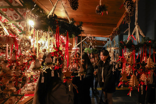 Holiday ornaments frame a view of shoppers browsing at the Christmas market during the Christmas shopping season at Umeda Sky Building on December 18, 2025 in Osaka, Japan. (Photo by Buddhika Weerasinghe/Getty Images)