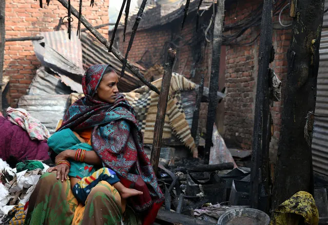 A woman feeds her baby amongst the rubble of her home after a fire in a slum area left hundreds homeless in the old quarters of Delhi, India, November 8, 2016. (Photo by Cathal McNaughton/Reuters)