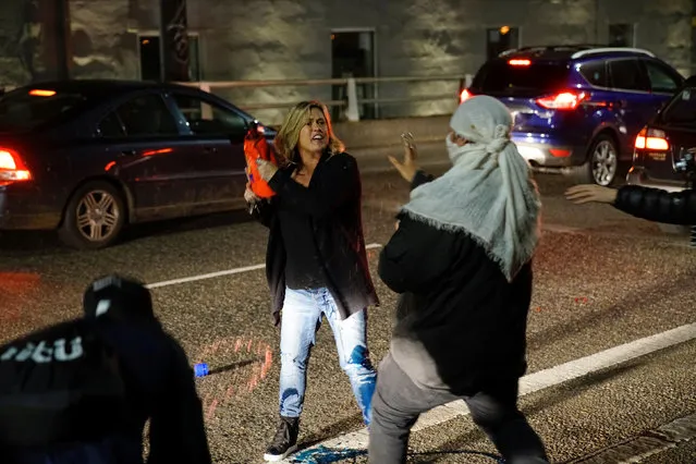 A motorist who was caught in the middle of a riot threatens a demonstrator with detergent during a protest against the election of Republican Donald Trump as President of the United States in Portland, Oregon, U.S. November 10, 2016. (Photo by William Gagan/Reuters)