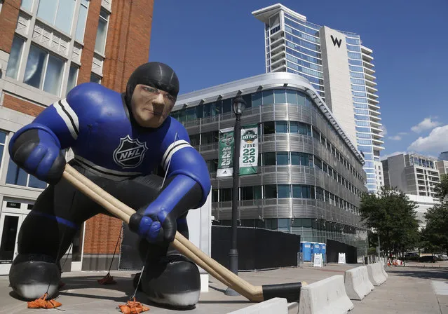 An inflatable hockey player stands outside the site of the NHL hockey draft in Dallas, Friday, June 22, 2018. (Photo by Michael Ainsworth/AP Photo)