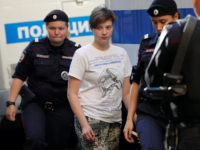 Olga Pakhtusova, one of four members of Russia's p*ssy Riot protest group who were jailed for 15 days for staging a pitch invasion during the football World Cup final and were detained again after their release on July 30, is escorted by police officers outside a court building in Moscow, Russia July 31, 2018. (Photo by Tatyana Makeyeva/Reuters)