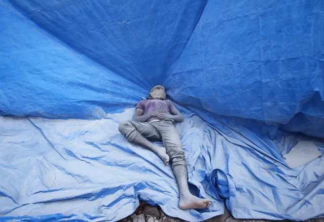 A worker with his face covered rests on a tarpaulin at a construction site of a residential complex in Bengaluru, India December 16, 2015. (Photo by Abhishek N. Chinnappa/Reuters)