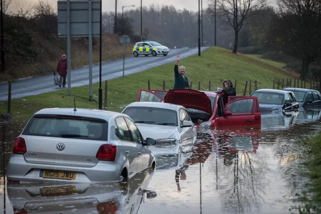 A resident waves as they attend to car that has been striken in flood water in Hartcliffe, after heavy rain fall from last night and today flooded the street on November 21, 2016 in Bristol, England. Yesterday Storm Angus brought hurricane force winds to southern Britain which brought flooding and power cuts to thousands of homes and today the storm has been replaced by a second wet weather front that has brought a band of heavy rain across the South West. (Photo by Matt Cardy/Getty Images)