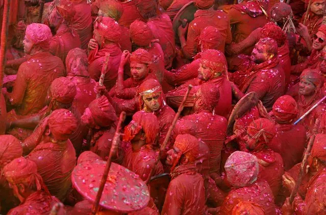 Men daubed in colors take part in Lathmar Holi celebrations in the town of Nandgaon, in the northern state of Uttar Pradesh, India, March 24, 2021. (Photo by K.K. Arora/Reuters)