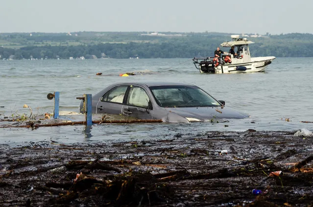 A car floats in Seneca Lake as crews attempt to drag a shed out of the water at Lodi Point in Lodi, N.Y., Wednesday, August 15, 2018, after heavy rain and flash flooding Tuesday led to evacuations and destruction in the Finger Lakes region. (Photo by Heather Ainsworth/AP Photo)