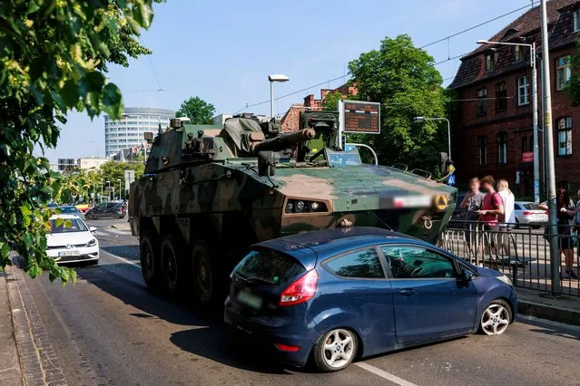 A damaged car sits at the crash site next to a wheeled armored personnel carrier KTO Rosomak following a collision, in Wroclaw, western Poland, 20 June 2023. No victims or injuries were reported so far. (Photo by Tomasz Golla/EPA/EFE)