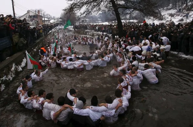 Bulgarian men dance in the icy waters of the Tundzha river during a celebration for Epiphany Day in the town of Kalofer, Bulgaria January 6, 2016. (Photo by Stoyan Nenov/Reuters)