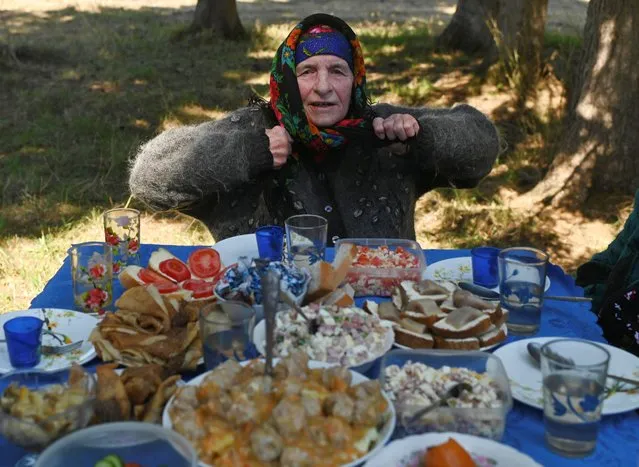 A local resident has a feast on Victory Day, which marks the 76th anniversary of the victory over Nazi Germany in World War Two, in the settlement of Sovetskaya Krestyanka in Omsk Region, Russia on May 9, 2021. (Photo by Alexey Malgavko/Reuters)