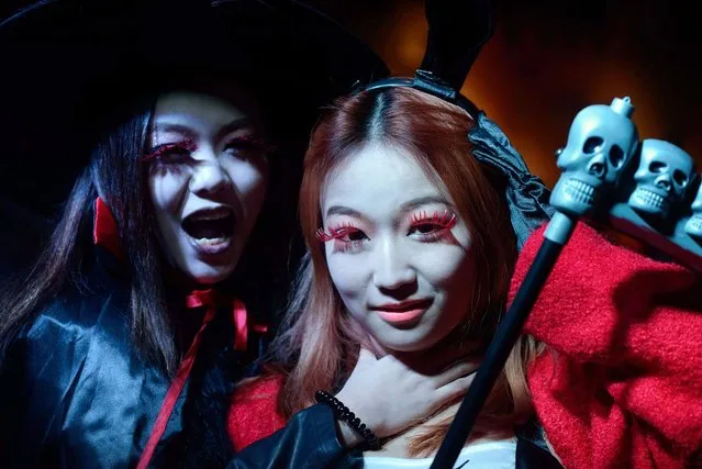 Women in costumes pose while revellers celebrate Halloween in Beijing on October 31, 2013. (Photo by Ed Jones/AFP Photo)