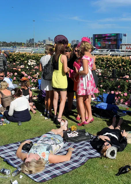 Race goers enjoy the atmosphere at the end of the day at the Melbourne Cup at Flemington Racecourse in Melbourne, Tuesday, November 5, 2013. (Photo by Joe Castro/AAP/Press Association Images)