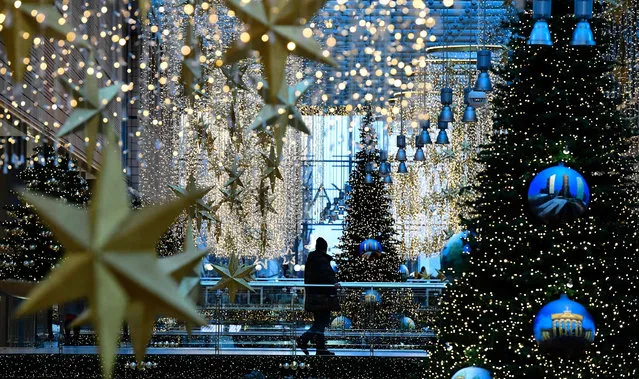 People take a walk at a shopping mall festively decorated for Christmas in Berlin on November 29, 2016. (Photo by Tobias Schwarz/AFP Photo)