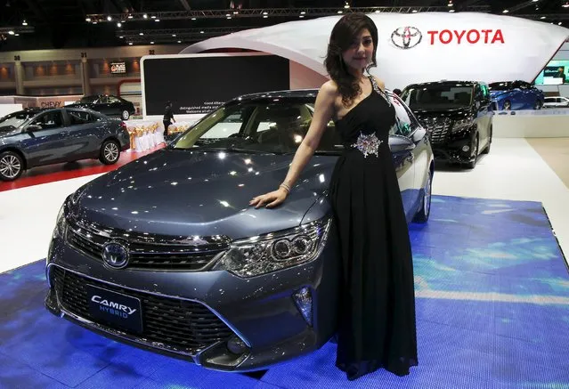 A model poses beside a Toyota Camry Hybrid during a media presentation of the 36th Bangkok International Motor Show in Bangkok March 24, 2015. (Photo by Chaiwat Subprasom/Reuters)