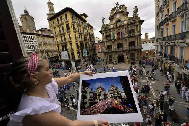 Cristina Esparza holds a San Fermin July 2019 photograph, in Pamplona, northern Spain, Tuesday July 6, 2021, on the day the “txupinazo” would usually take place to start the famous San Fermin festival, which was canceled once more year due to COVID-19 pandemic. (Photo by Alvaro Barrientos/AP Photo)