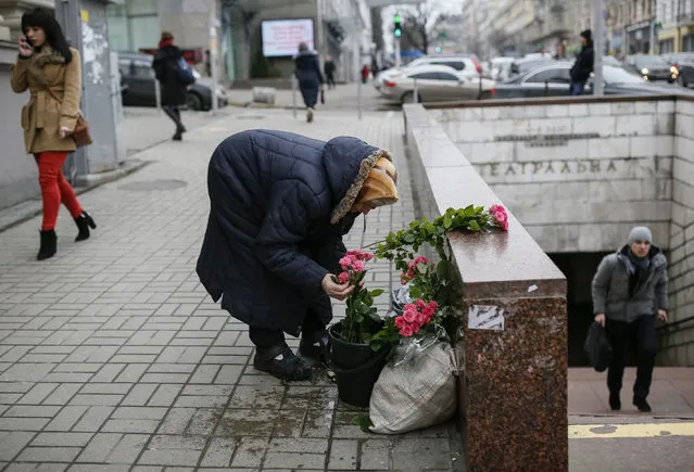 A woman arranges bouquets of flowers as she waits for customers in central Kiev, Ukraine, February 4, 2016. (Photo by Gleb Garanich/Reuters)