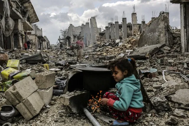 Kurdish Syrian girls are pictured among destroyed buildings in the Syrian Kurdish town of Kobane, also known as Ain al-Arab, on March 22, 2015. (Photo by Yasin Akgul/AFP Photo)