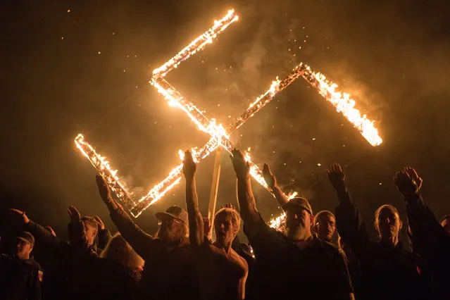 Supporters of the National Socialist Movement, a white nationalist group based in the U.S., give Nazi salutes while taking part in a swastika burning at an undisclosed location in Georgia, April 21, 2018. (Photo by Go Nakamura/Reuters)