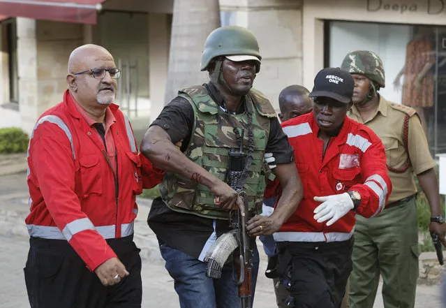 An injured member of the security forces is helped by paramedics at a hotel complex in Nairobi, Kenya Tuesday, January 15, 2019. Terrorists attacked an upscale hotel complex in Kenya's capital Tuesday, sending people fleeing in panic as explosions and heavy gunfire reverberated through the neighborhood. (Photo by Ben Curtis/AP Photo)