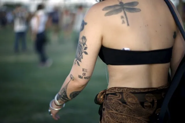 A woman displays a “hell or high water” tattoo as she walks through the Coachella Valley Music and Arts Festival in Indio, California April 10, 2015. (Photo by Lucy Nicholson/Reuters)