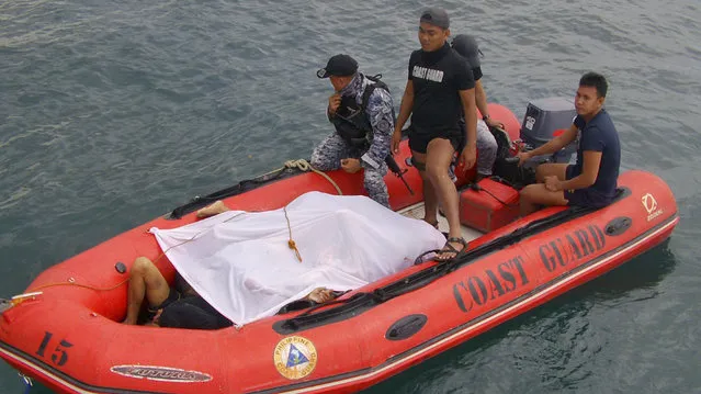 In this photo provided by the Philippine Coast Guard, members of the Philippine Coast Guard bring bodies of Filipino fishermen who were killed by suspected pirates in waters near Zamboanga City, southern Philippines Tuesday, January 10, 2017. Several Filipino fishermen were killed after a group of suspected pirates boarded a fishing boat in southern Philippine waters and strafed the crew, officials said Tuesday. (Photo by Philippine Coast Guard via AP Photo)