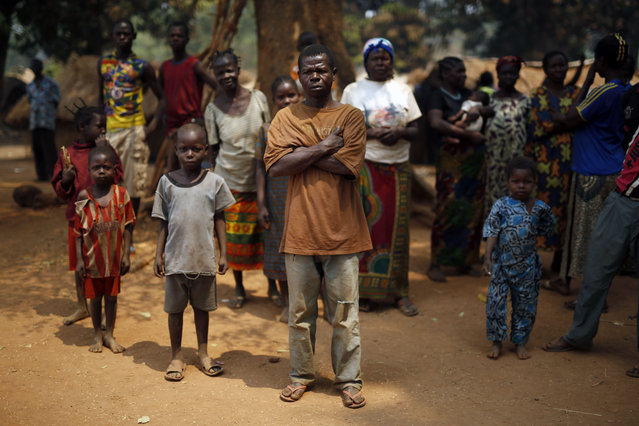 Christian families living in a refugee camp stand under a tree in Kaga-Bandoro, Central African Republic, Tuesday February 16,  2016. Refugees in the north of Central African Republic say they hope the new president will bring peace but no one is heading home just yet. Thousands are still living in displacement camps in Kaga-Bandoro, a stronghold of the former Muslim rebel group known as Seleka that was in power for nearly a year. The one-time rebels say they are waiting to see how the election turns out before taking any action. (Photo by Jerome Delay/AP Photo)