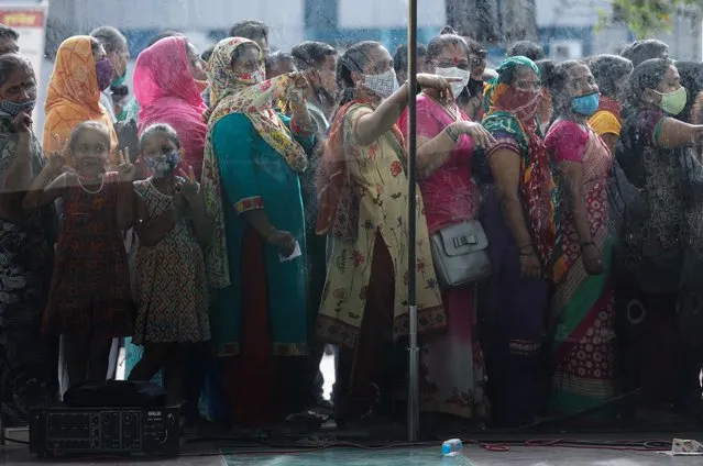 People wait in a queue to receive the vaccine against coronavirus disease (COVID-19) outside a shopping mall in Mumbai, India, August 11, 2021. (Photo by Francis Mascarenhas/Reuters)