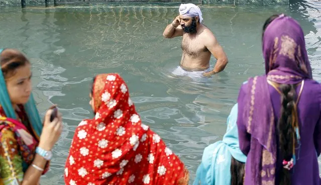 A Sikh devotee washes himself in the holy water at Panja Sahib in Hassan Abdel April 13, 2015. Hundreds of Indian Sikh pilgrims arrived into Pakistan to celebrate the Baisakhi festival with Pakistani Sikhs at the shrines of Panja Sahib and Nankana Sahib, the birth place of Sikh faith founder Guru Nanak Dev. (Photo by Caren Firouz/Reuters)