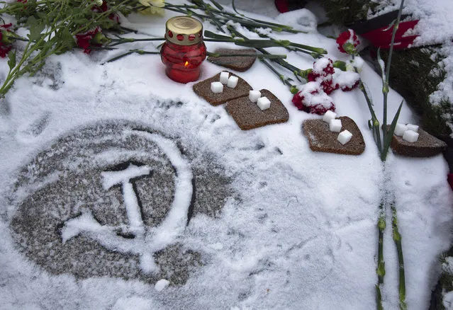 Pieces of bread and sugar at the Piskaryovskoye Cemetery where most of the Leningrad Siege victims were buried during World War II, in St.Petersburg, Russia, Saturday, January 26, 2019. (Photo by Dmitri Lovetsky/AP Photo)