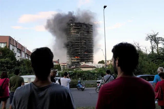 Smoke billows from a building in Milan, Italy, Sunday, August 29, 2021. Firefighters were battling a blaze on Sunday that spread rapidly through a recently restructured 60-meter-high, 16-story residential building in Milan. There were no immediate reports of injuries or deaths. (Photo by Luca Bruno/AP Photo)