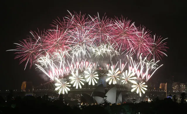 Fireworks explode over the Harbour Bridge and the Opera House during New Year's Eve celebrations in Sydney, Australia, Wednesday, January 1, 2014. (Photo by Rob Griffith/AP Photo)