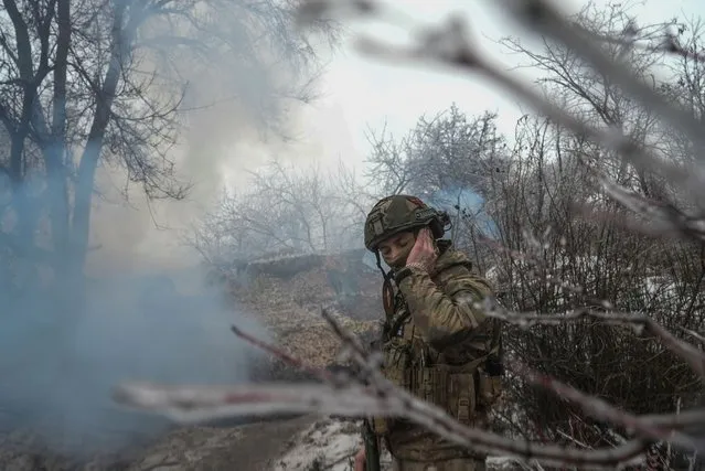 A Ukrainian serviceman of the Ukrainian 92nd Ivan Sirko Separate Assault Brigade covers his ear during fire from a 2S1 Gvozdika self-propelled howitzer toward Russian troops in a front line near the town of Bakhmut, amid Russia's attack on Ukraine, in Donetsk region, Ukraine on December 15, 2023. (Photo by Inna Varenytsia/Reuters)