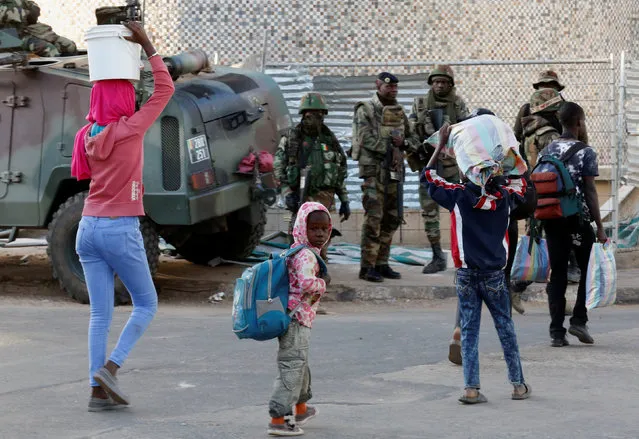 Children walk past regional ECOWAS troops in Banjul, Gambia January 23, 2017. (Photo by Thierry Gouegnon/Reuters)