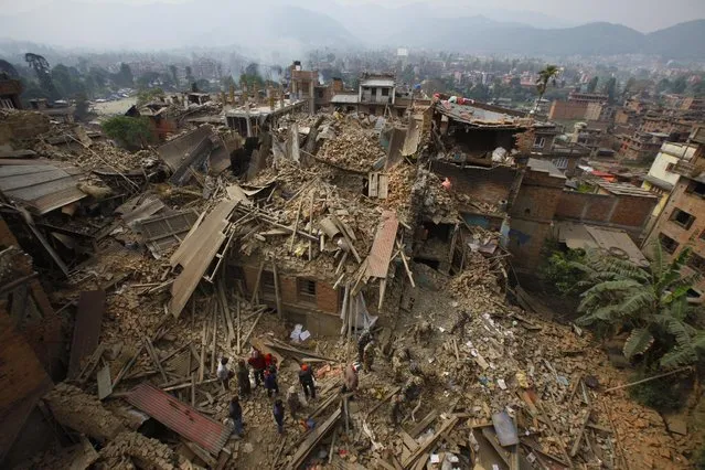 Rescue workers remove debris as they search for victims of earthquake in Bhaktapur near Kathmandu, Nepal, Sunday, April 26, 2015. (Photo by Niranjan Shrestha/AP Photo)