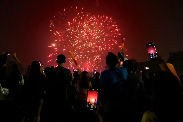 People watch as fireworks light up the sky at Rizal Park ushering in the New Year in Manila on January 1, 2024. (Photo by Jamillah Sta. Rosa/AFP Photo)
