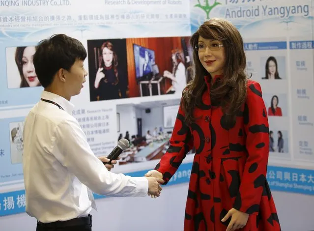 A man shakes hands with a humanoid robot named “Yangyang” showing a facial expression, during its demonstration at the Global Mobile Internet Conference (GMIC) 2015 in Beijing, China,  April 29,  2015. (Photo by Kim Kyung-Hoon/Reuters)