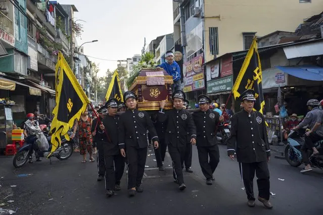 Pallbearers carry a casket through neighborhoods as part of a funeral procession in Ho Chi Minh City, Vietnam, January 12, 2024. (Photo by Jae C. Hong/AP Photo)